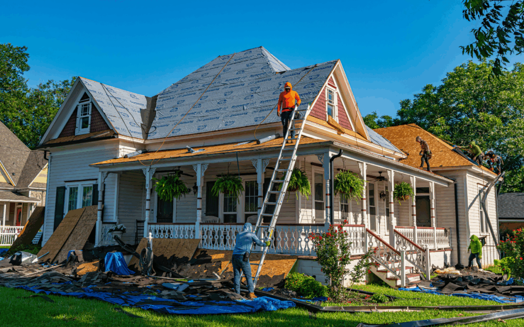 Workers replacing the roof of an older Hampton Roads home during major repairs on a sunny day.